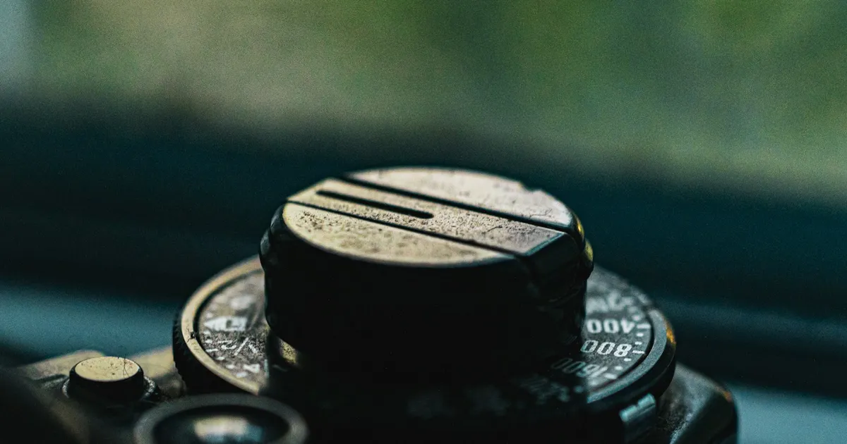 The shutter speed dial of a vintage camera, numbers picked out in the light